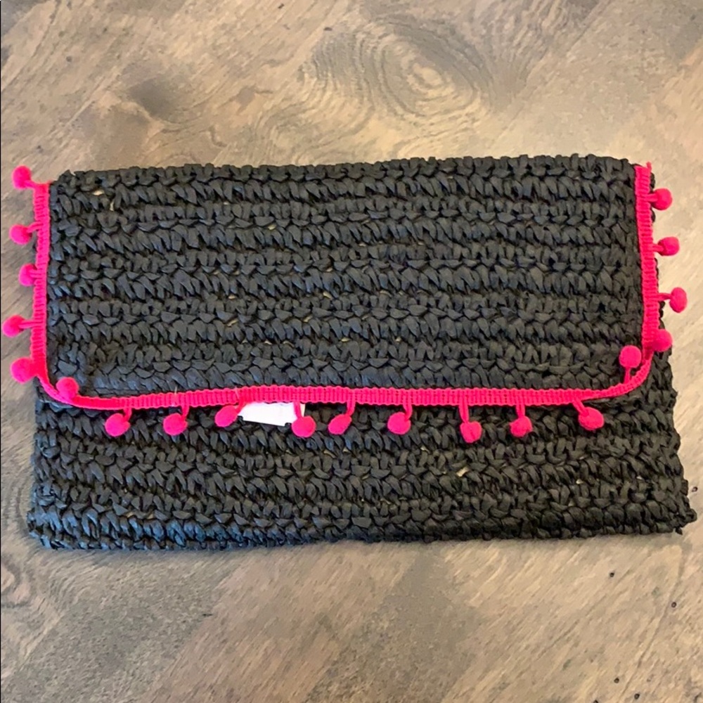 Black straw-like clutch with pink Pom-Pom trim